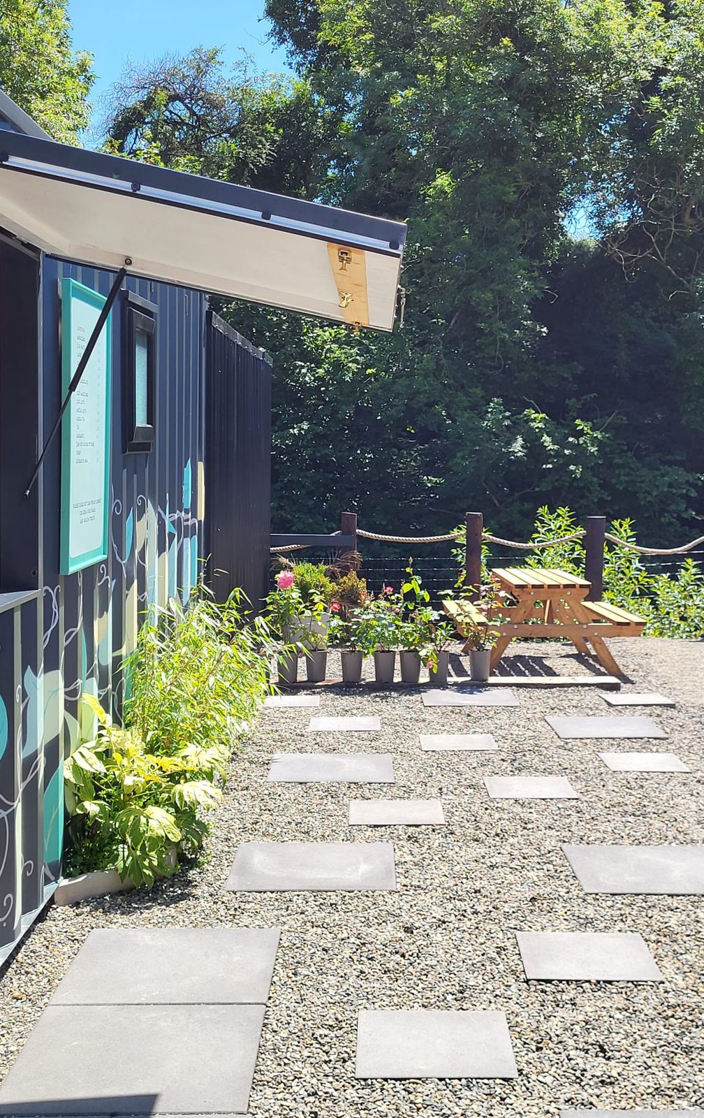 The gravel terrace with stepping stones beside the painted coffee hatch