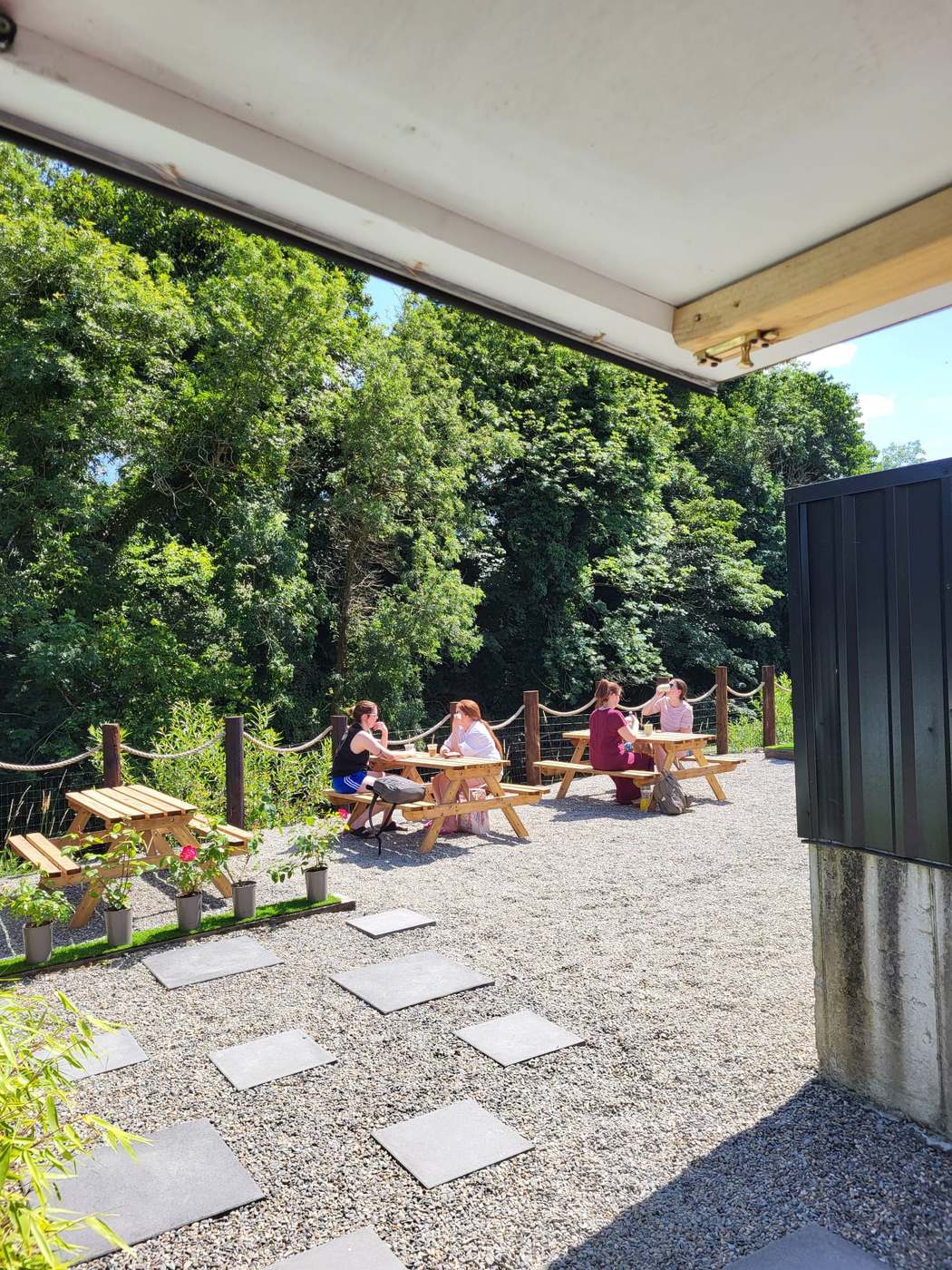 The view from the coffee hatch: friends at picnic tables along the riverbank