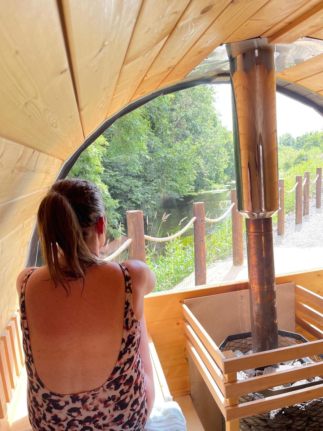 Looking out from the sauna bench, past the stove, to the river